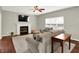 Cozy living room with a fireplace, neutral furniture, and a ceiling fan at 13191 Roma, Carmel, IN 46074