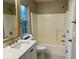 Bathroom with a bathtub, sink, and toilet, all well-lit by the window at 13262 Landwood Dr, Fishers, IN 46037