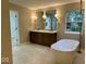 Spacious bathroom featuring double sinks, a soaking tub, and a view from the window at 13262 Landwood Dr, Fishers, IN 46037