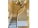 Foyer featuring a chandelier and staircase with wood trim and gray carpet at 13262 Landwood Dr, Fishers, IN 46037