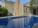 Back of home featuring an in-ground pool with blue water and reflection of the home's architecture at 13262 Landwood Dr, Fishers, IN 46037