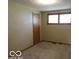 Bedroom features carpeted floors, a window that provides ample natural light, and a paneled door at 1333 S B St, Elwood, IN 46036