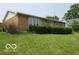 Exterior view of a brick home with green lawn and mature bushes at 1333 S B St, Elwood, IN 46036