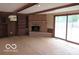Living room with brick fireplace and sliding glass doors to the backyard, providing plenty of natural light at 1333 S B St, Elwood, IN 46036