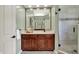 Stylish bathroom featuring a wood vanity with modern fixtures and a tiled shower at 1411 N Claridge Way, Carmel, IN 46032