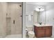 Modern bathroom with glass-enclosed shower, dark wood vanity, and ample counter space at 1411 N Claridge Way, Carmel, IN 46032