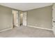 Empty bedroom featuring neutral decor, plush carpet, and multiple doorways at 1411 N Claridge Way, Carmel, IN 46032