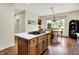 Open kitchen features an island with cooktop and breakfast bar and eating area by window at 1411 N Claridge Way, Carmel, IN 46032