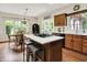 Open kitchen boasts an island with seating and cooktop and eating area with natural light at 1411 N Claridge Way, Carmel, IN 46032
