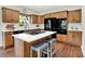 Modern kitchen with wood cabinets, granite countertops, an island cooktop, and stainless steel appliances at 1411 N Claridge Way, Carmel, IN 46032
