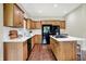 Updated kitchen with stainless appliances, light countertops, an island with a cooktop, and wood cabinets at 1411 N Claridge Way, Carmel, IN 46032