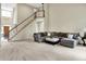 Spacious living room with a staircase, neutral carpet, and comfortable gray sectional sofa at 1411 N Claridge Way, Carmel, IN 46032