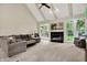 Vaulted living room with ceiling fan, fireplace, French doors, and comfortable seating area at 1411 N Claridge Way, Carmel, IN 46032