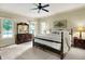 Relaxing main bedroom with neutral decor, large bed, and a dresser with mirror at 1411 N Claridge Way, Carmel, IN 46032
