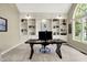 Well-lit home office featuring custom shelving, large arched window, and a modern desk setup at 1411 N Claridge Way, Carmel, IN 46032