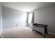 Bedroom with tan carpet and light gray walls, featuring a window with gray drapes and a baby's playpen at 16095 Tenor Way, Noblesville, IN 46060