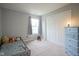 Bedroom featuring a daybed, neutral carpet, a window with gray drapes, and a blue dresser at 16095 Tenor Way, Noblesville, IN 46060