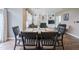 Cozy dining room with a wooden table set, flowing into a living room with built-in shelving at 16095 Tenor Way, Noblesville, IN 46060