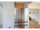 Spacious refrigerator in kitchen, next to hardwood floors and a glimpse into the living area at 16095 Tenor Way, Noblesville, IN 46060