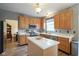Well-lit kitchen features wooden cabinets, stainless appliances, a central island, and marble countertops at 16095 Tenor Way, Noblesville, IN 46060