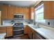 Updated kitchen showcasing stainless steel appliances, marble countertops, and wood cabinetry at 16095 Tenor Way, Noblesville, IN 46060