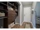 Efficient laundry room featuring wooden floors, closet shelving and door to the outside at 16095 Tenor Way, Noblesville, IN 46060