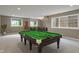 A finished basement with a pool table, seating, and natural light from the surrounding windows at 16548 Grand Cypress Dr, Noblesville, IN 46060