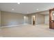 A spacious, carpeted basement featuring neutral walls, recessed lighting, and access to a kitchenette at 16548 Grand Cypress Dr, Noblesville, IN 46060