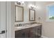 Bathroom with double sink vanity, granite countertops, dark wood cabinets, and sconce lighting at 16548 Grand Cypress Dr, Noblesville, IN 46060