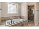 Modern bathroom featuring a soaking tub, tiled shower, and natural light at 16548 Grand Cypress Dr, Noblesville, IN 46060