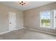 Bedroom with neutral walls, carpet, overhead lighting, and a bright window with green views at 16548 Grand Cypress Dr, Noblesville, IN 46060