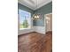 Dining room area featuring hardwood floors, wainscoting, a modern chandelier, and a large window at 16548 Grand Cypress Dr, Noblesville, IN 46060