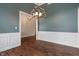 An elegant dining room showcases hardwood floors, a modern chandelier, and stylish wainscoting at 16548 Grand Cypress Dr, Noblesville, IN 46060