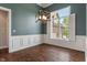 Dining room with hardwood flooring, wainscoting, large window, and modern chandelier at 16548 Grand Cypress Dr, Noblesville, IN 46060