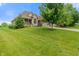 A large home on a green lawn, featuring stone and siding, a three-car garage and a covered porch at 16548 Grand Cypress Dr, Noblesville, IN 46060