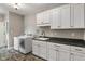 Laundry room with white cabinetry, dark countertops, tile flooring, and a washer and dryer at 16548 Grand Cypress Dr, Noblesville, IN 46060