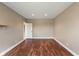 Neutral room with hardwood floors, a door, base trim, and a lone shelf at 16548 Grand Cypress Dr, Noblesville, IN 46060