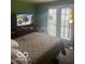 Spacious bedroom with bed, dresser, TV, and access to the outdoors at 2021 Columbia Ave, Indianapolis, IN 46202