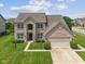 Traditional two-story brick home featuring an attached garage and manicured lawn at 2078 Seneca Ln, Plainfield, IN 46168
