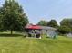 Expansive backyard featuring a covered patio, fire pit with chairs, and above ground swimming pool at 2213 Holden Dr, Anderson, IN 46012