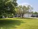 Attractive brick home featuring a manicured lawn, mature trees, and an attached two-car garage at 2213 Holden Dr, Anderson, IN 46012