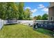View of the backyard with a pool, trampoline, grill, deck and a white fence at 2384 Fairfax Dr, Columbus, IN 47203