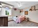 Cozy bedroom featuring neutral colors, a ceiling fan, and a large window at 2384 Fairfax Dr, Columbus, IN 47203