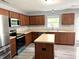 Kitchen with stainless steel appliances, dark wood cabinets, and an island with light countertops at 3314 Montgomery Dr, Indianapolis, IN 46227