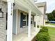 Front porch area featuring white pillars, light brick facade, and manicured landscaping at 3314 Montgomery Dr, Indianapolis, IN 46227