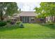 Brick home back exterior with well-manicured lawn, seating area, and surrounding trees at 3545 Inverness Blvd, Carmel, IN 46032