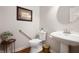 Neutral powder room featuring pedestal sink, toilet with safety bar, and hardwood floors at 3545 Inverness Blvd, Carmel, IN 46032