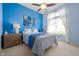 Bright bedroom features blue walls, carpet floors, a ceiling fan, a large window, and tasteful decor at 3545 Inverness Blvd, Carmel, IN 46032