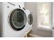 Bright laundry area with modern, front-loading washer and dryer set, next to a window at 3545 Inverness Blvd, Carmel, IN 46032
