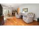 Comfortable living area featuring hardwood floors, a seating area, dining area, and abundant natural light from the windows at 3545 Inverness Blvd, Carmel, IN 46032